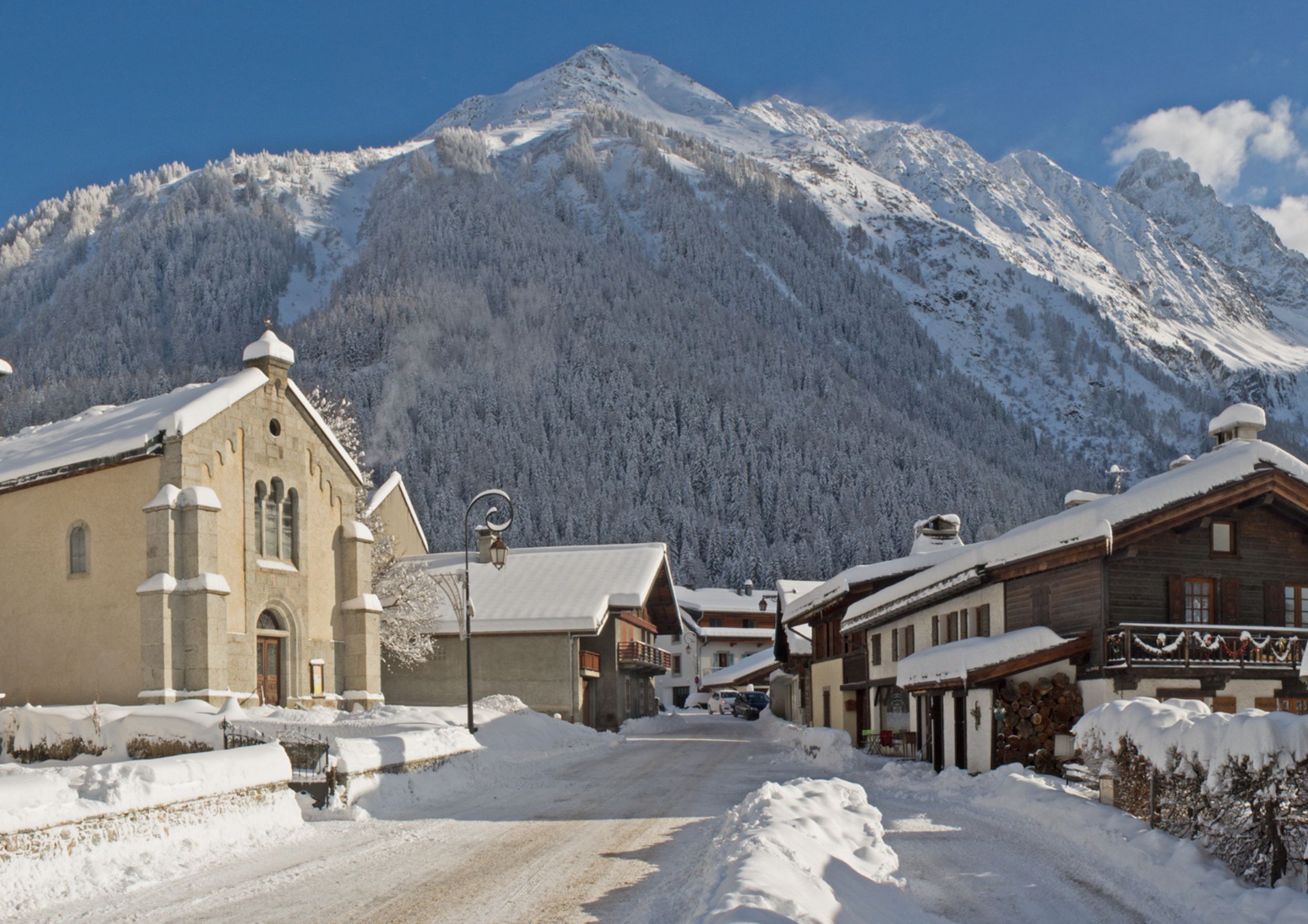 Argentiere village centre in winter with snow-covered chalets and church, Chamonix valley