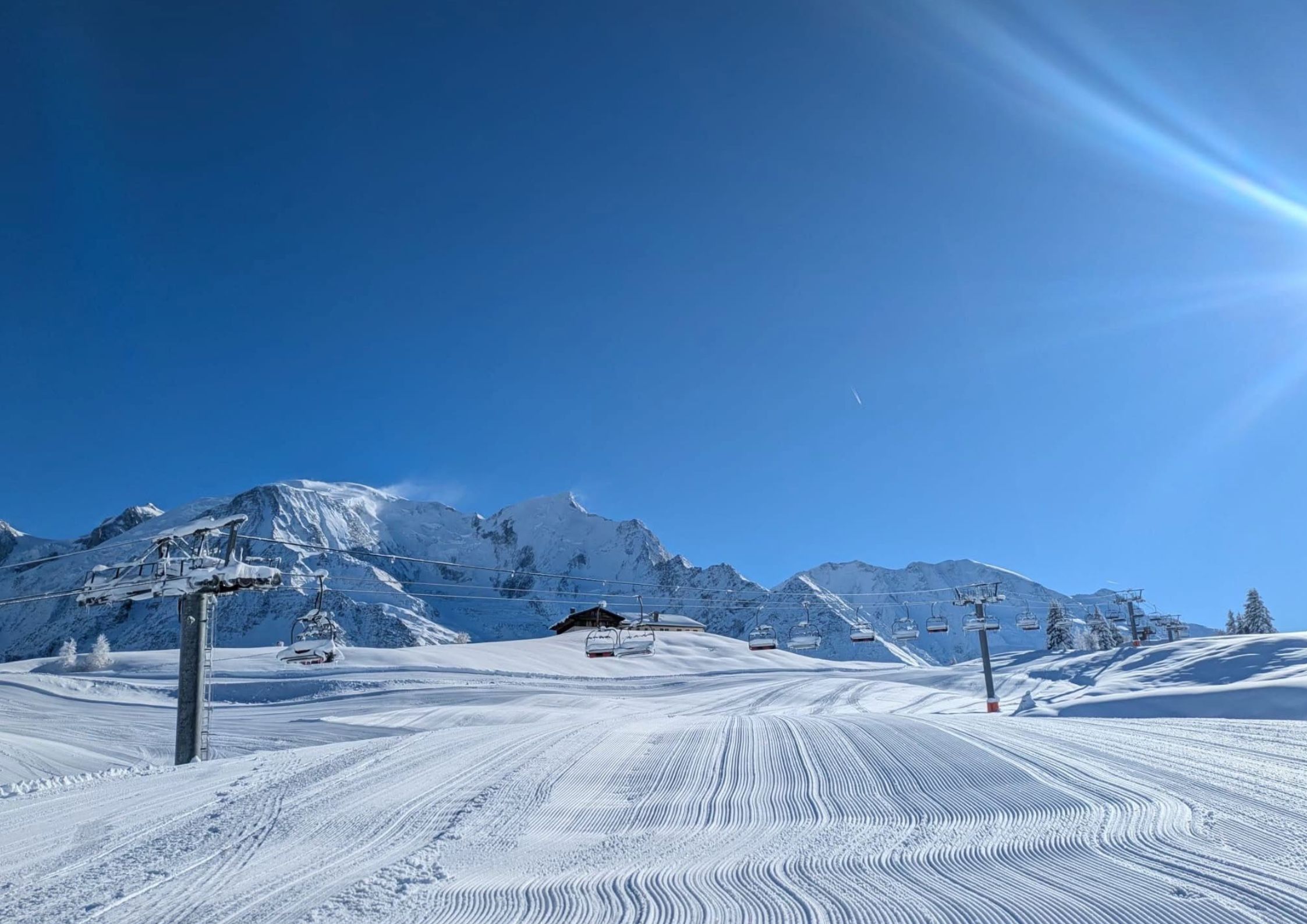 Les Carroz village from above in winter with traditional Savoyard chalets and snow-covered pine trees