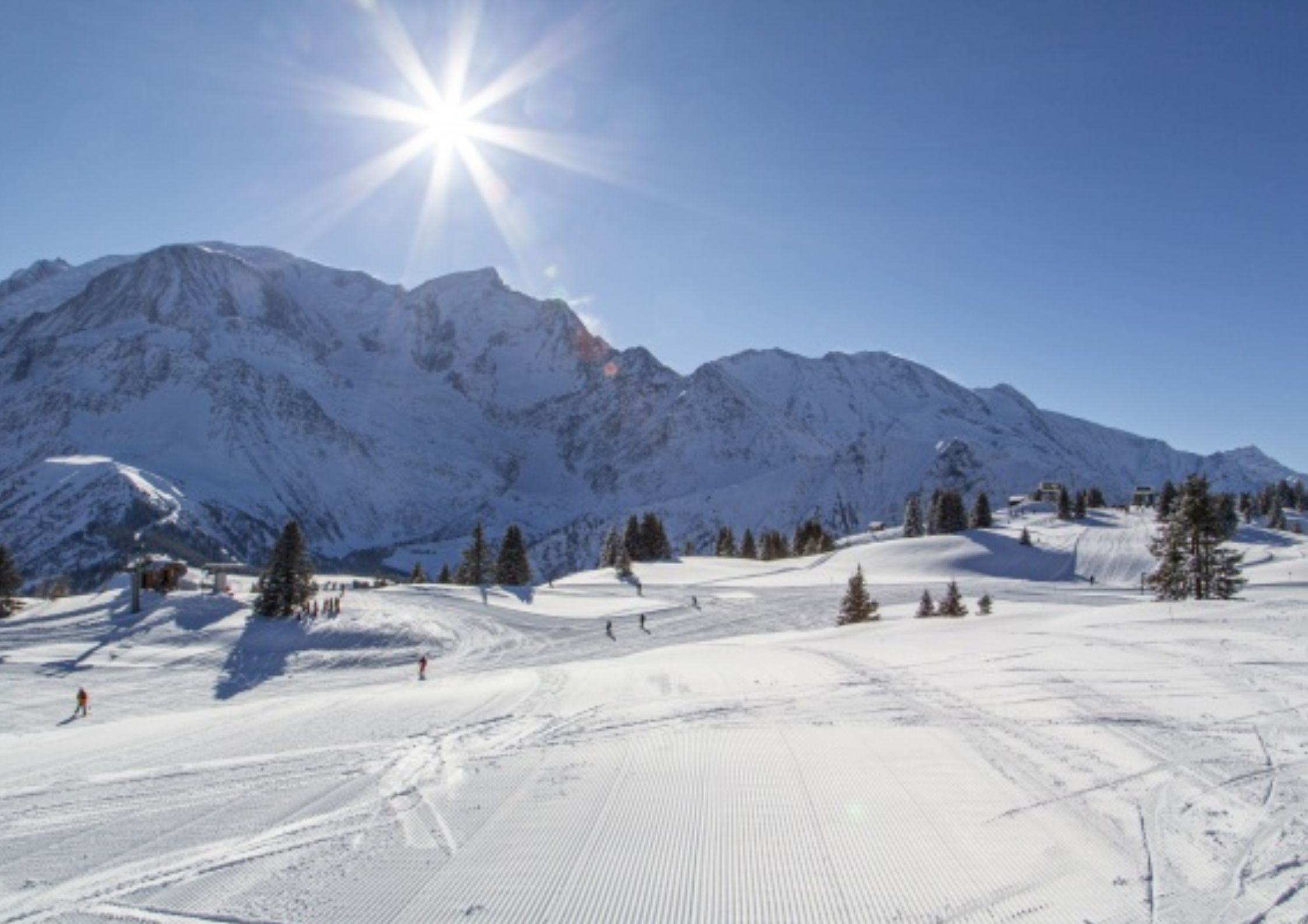 Les Carroz village from above in winter with traditional Savoyard chalets and snow-covered pine trees