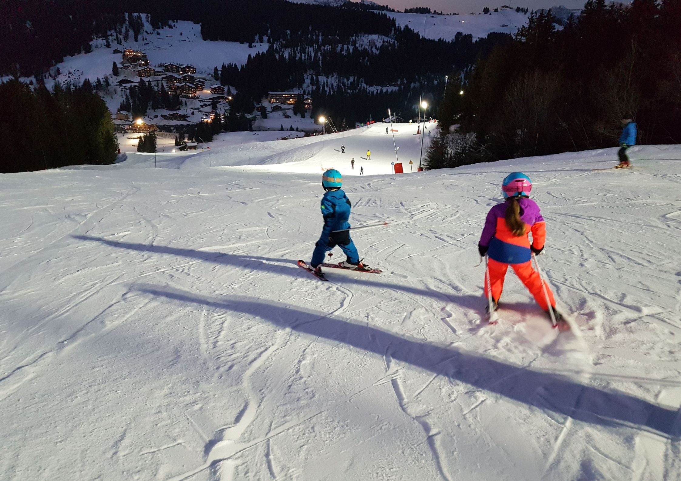 Manigod ski area from above with tree-lined pistes and Aravis mountain peaks in the background